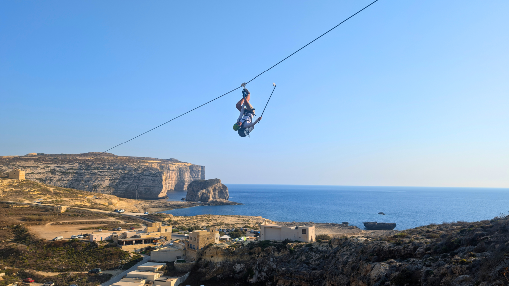 man upside down on the zipline in Dwejra Gozo